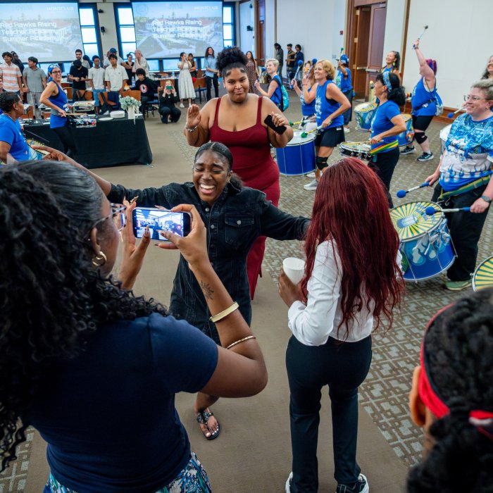 Students dancing and taking pictures while a band plays music