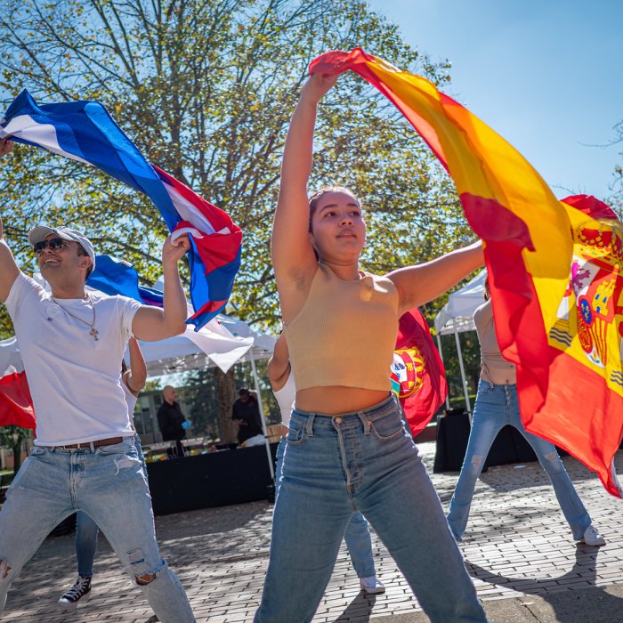 Students dancing with Latinx flags
