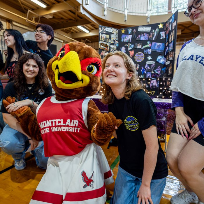 Students and mascot posing for a photo