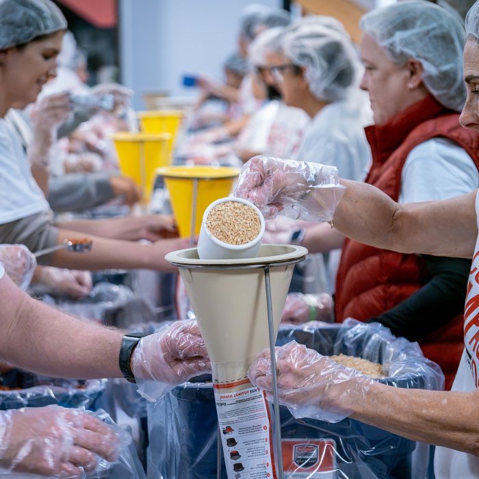 Montclair employees measure and bag food for Rise Against Hunger.