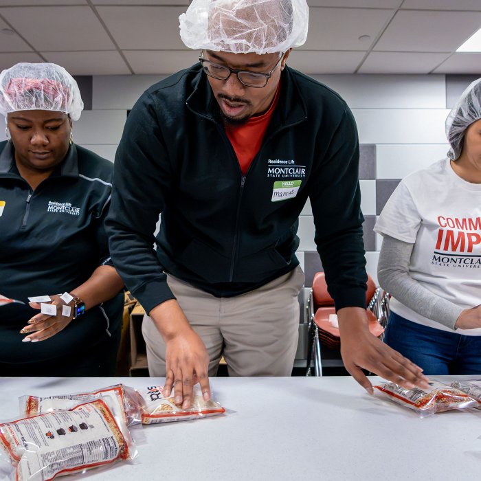 Employees sort through Rise Against Hunger bags of food for children.