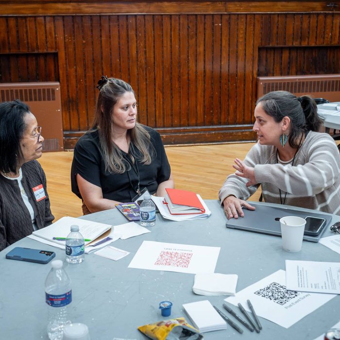 three attendees chatting at a table