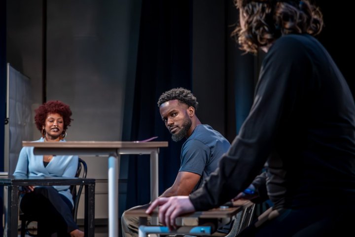 Actors on stage at a table