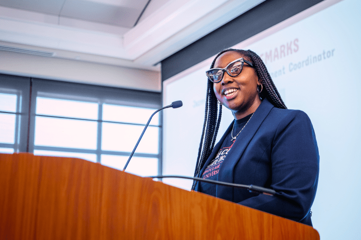 Graduate student presenter speaks at a podium.