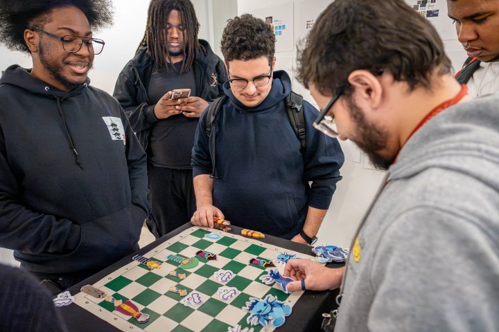 students gather to play a boardgame