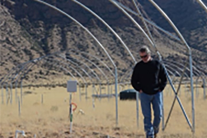 Dr. Scott Collins walking through the drought shelter at the University of New Mexico