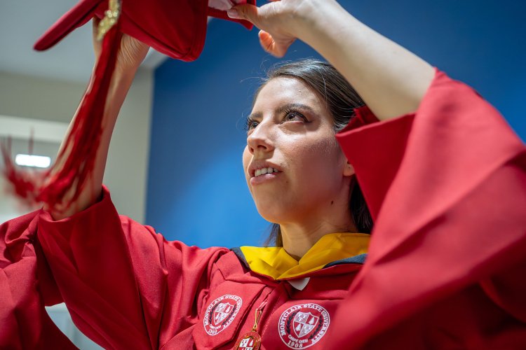 Andrea Uguna-Solano puts on her mortarboard.