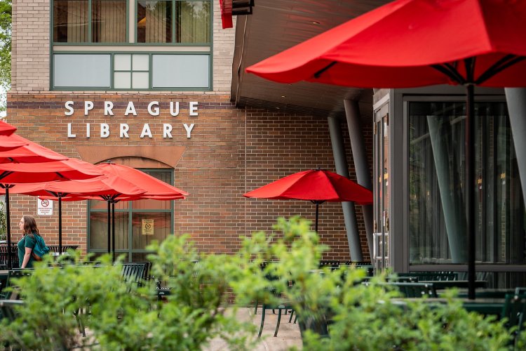 sprague library entrance with tables and umbrellas