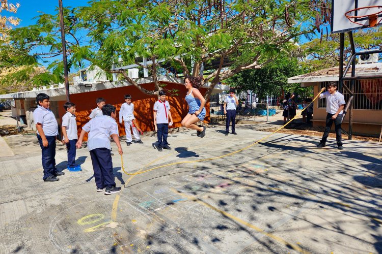 A Montclair student jumps rope in Mérida surrounded by group of children.