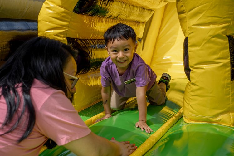 A child climbing through a blow up house