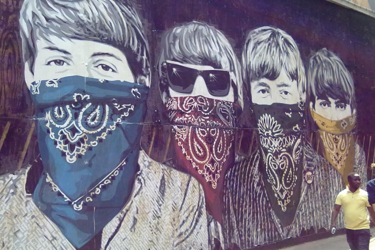 Picture of a mural with men covering their mouths with bandanas