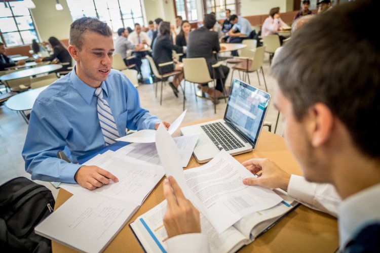 Two students working together with a laptop