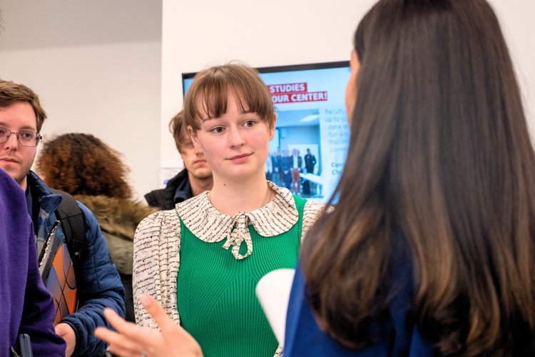 Students speaking to recruiter at a career fair event.