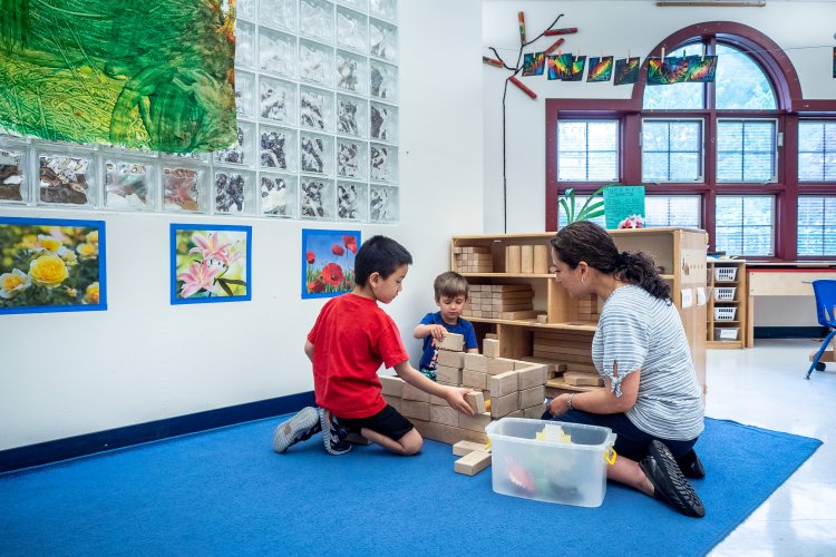 Teacher builds blocks with preschool children