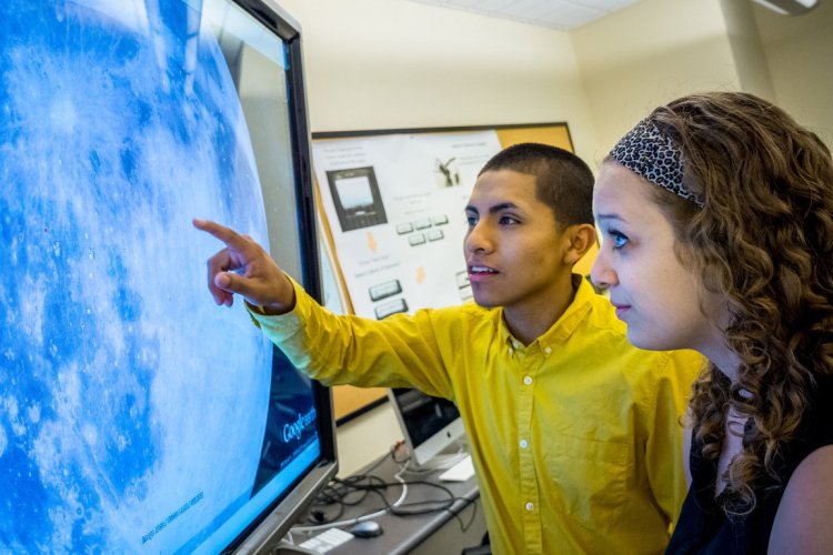 Two students look at a large screen