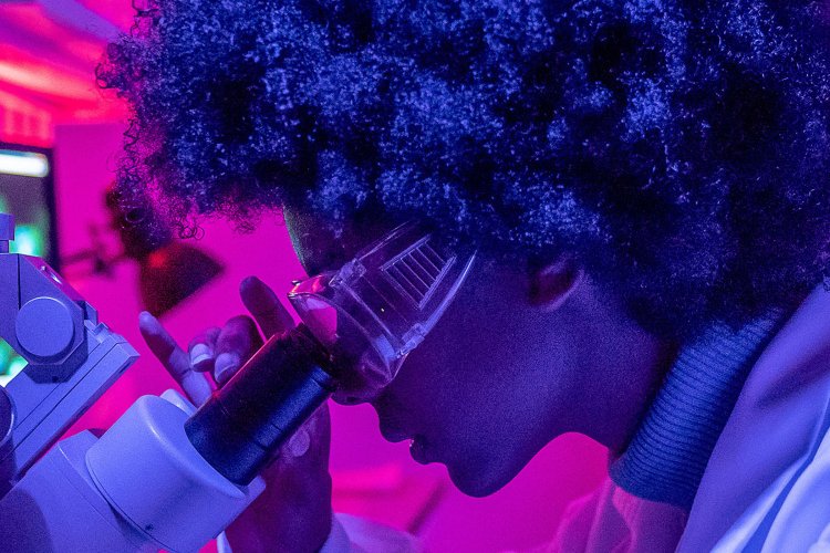 student using microscope