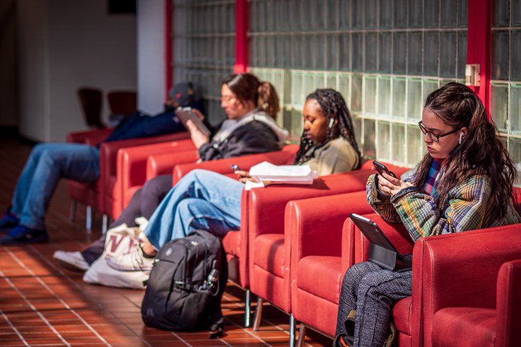 students sitting on red chairs