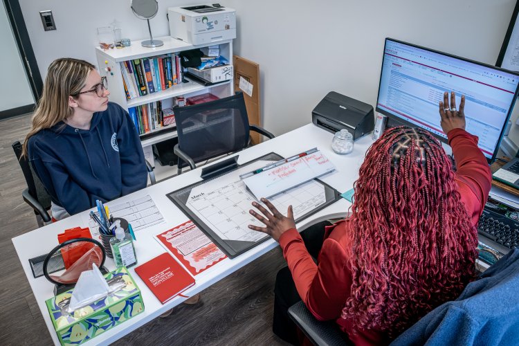 Advisor Helping Student at a desk
