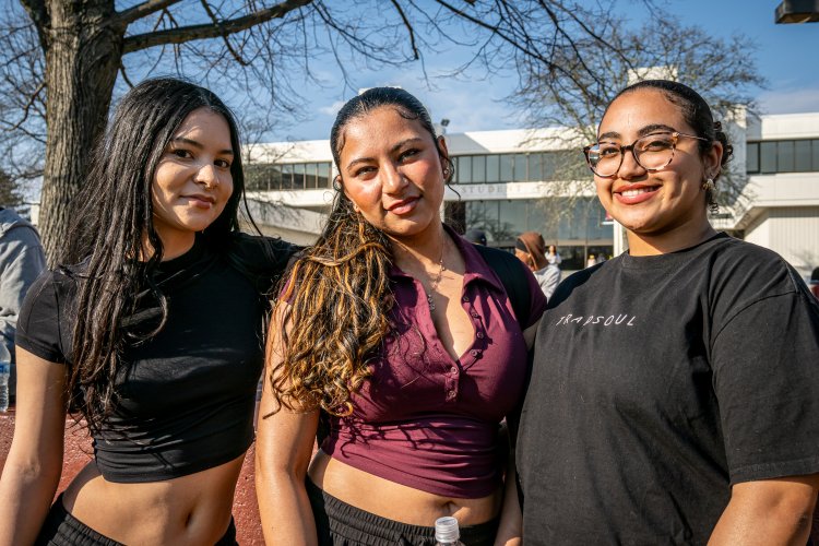 three students smiling on quad