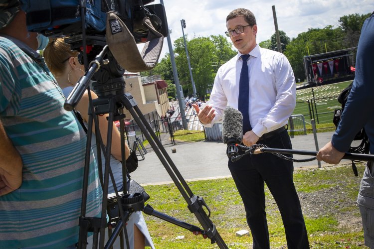 A person being interviewed by a reporter with camera person on campus outside
