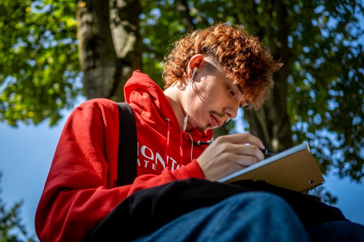 Student studies outside on campus