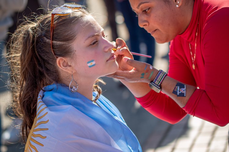 student in Argentinian flag, getting their face painted