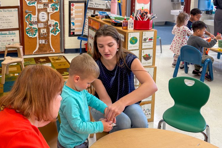 a teacher helps a student with a Veterans Day project
