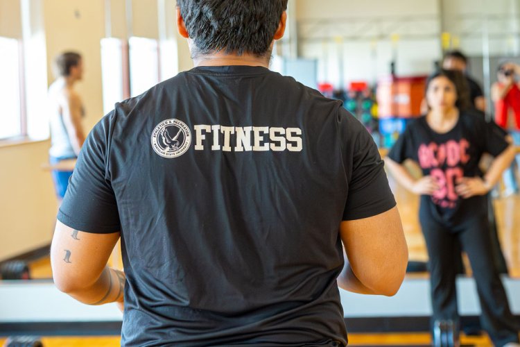 photo of an instructor with a shirt that says fitness on the back