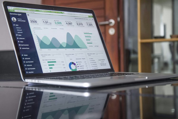 An open laptop displays graphs and charts on its screen