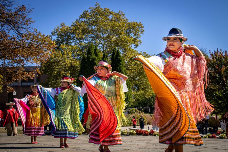 Four female dancers in traditional Peruvian attire performing a dance