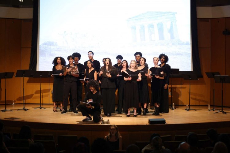 Group of college students singing together on stage during a choir performance