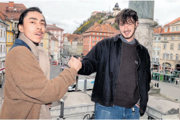 Two college students shaking hands in a town square in Austria