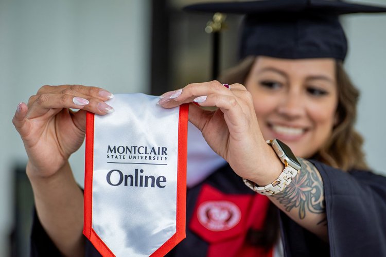 Online degree completion graduate wearing graduation gown and Montclair Online stole.