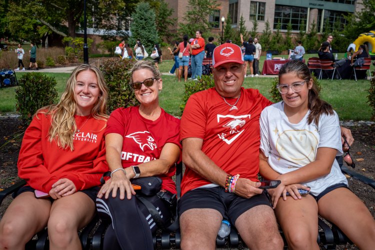 A family of four sitting on a bench 