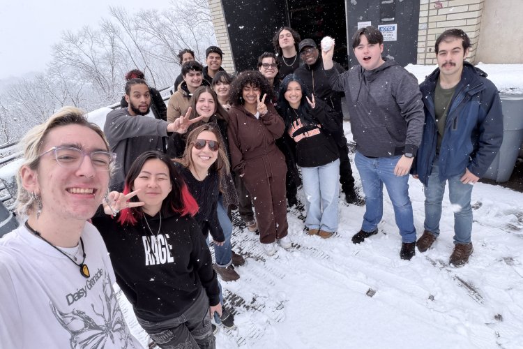 Students and Professor Poland pose for a photo outside.