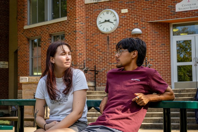 People sitting outside on green bench