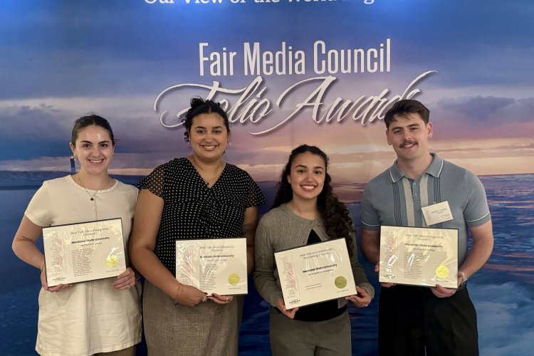 Four students holding their award certificates.