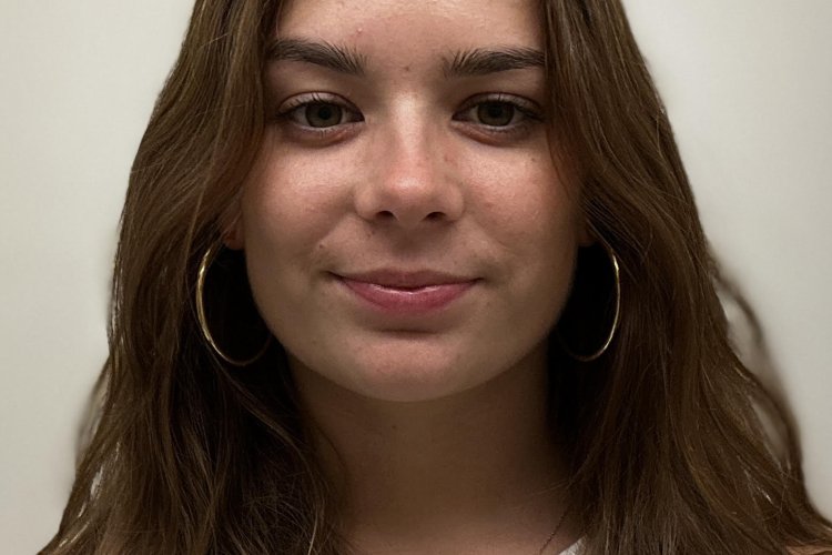 Student headshot against white wall.