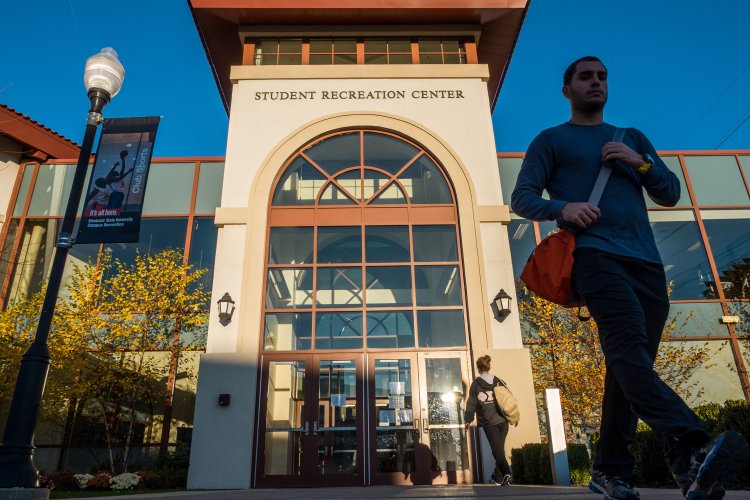 Student Recreation Center exterior with students coming out and into the building.