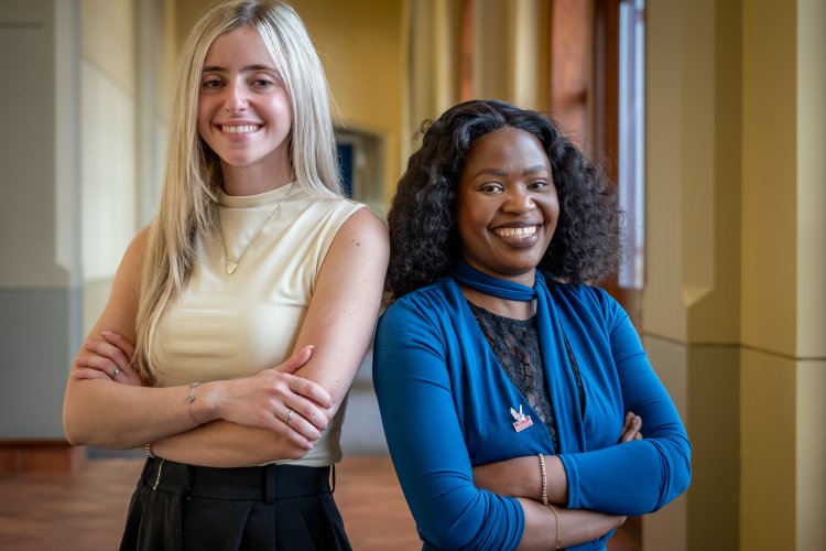 Two women standing back to back with arms crossed