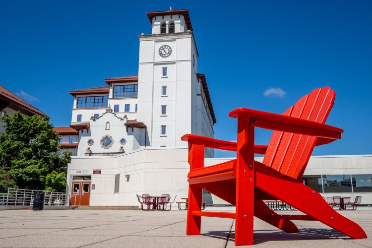 A red chair in front of university hall 