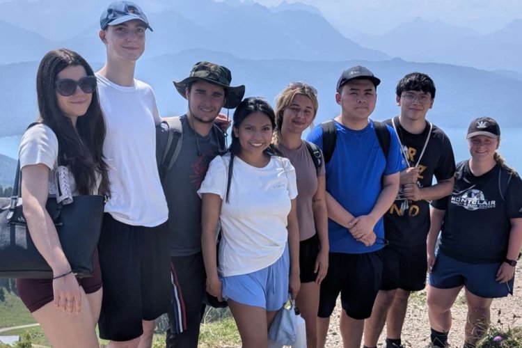 A group of college students pose on a peak in the German Alps