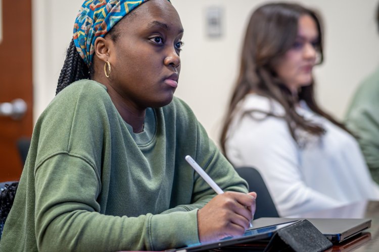 Student taking notes during a speech language pathology class. 
