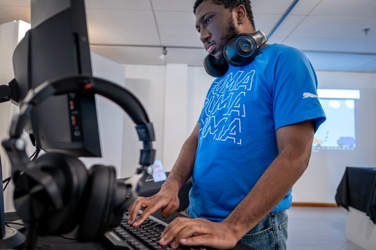 a game design student stands at a computer
