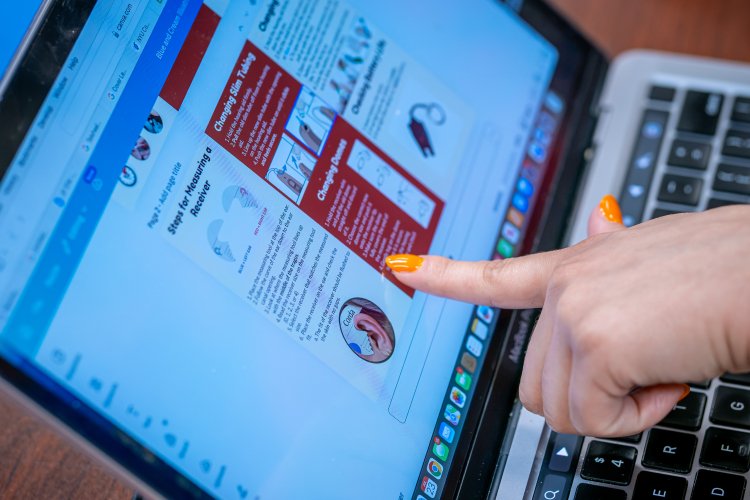 Student points to screen that shows process for fitting hearing aids.
