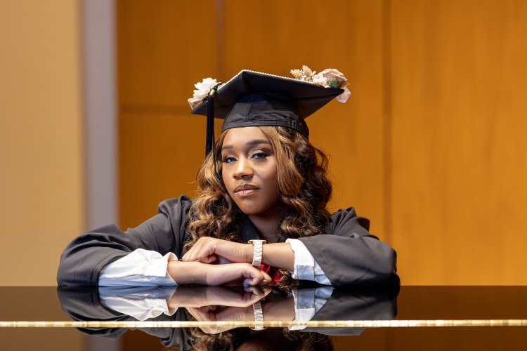 Lanaye Kemp with graduation cap and gown at piano