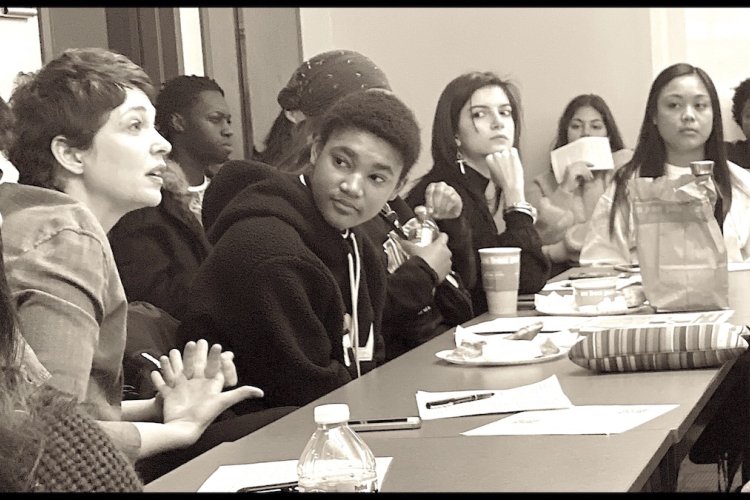 black and white photo of full classroom and students in discussion
