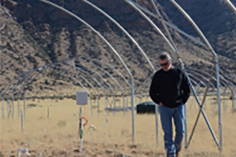 Dr. Scott Collins walking through the drought shelter at the University of New Mexico