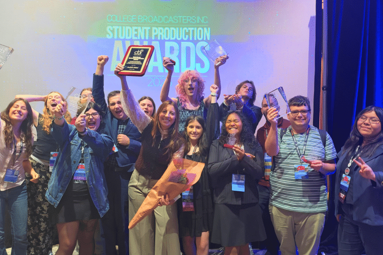 Group photo of students at the CBI Awards, cheering, smiling, and raising their awards.