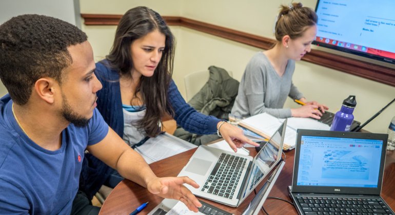 Students working on laptop in a study room